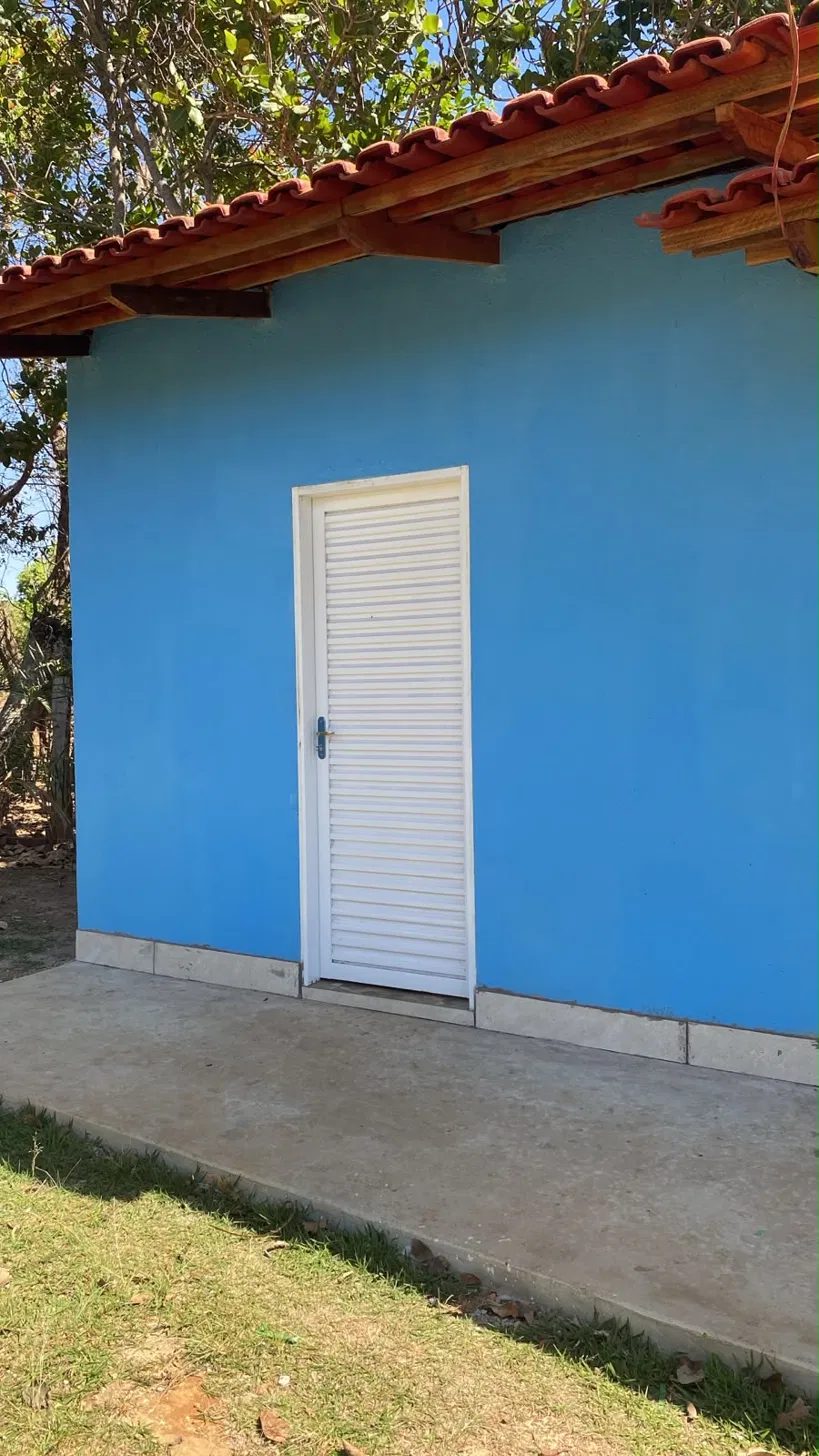 Chalé do Pescador, pintado em azul, com fachada simples e porta branca