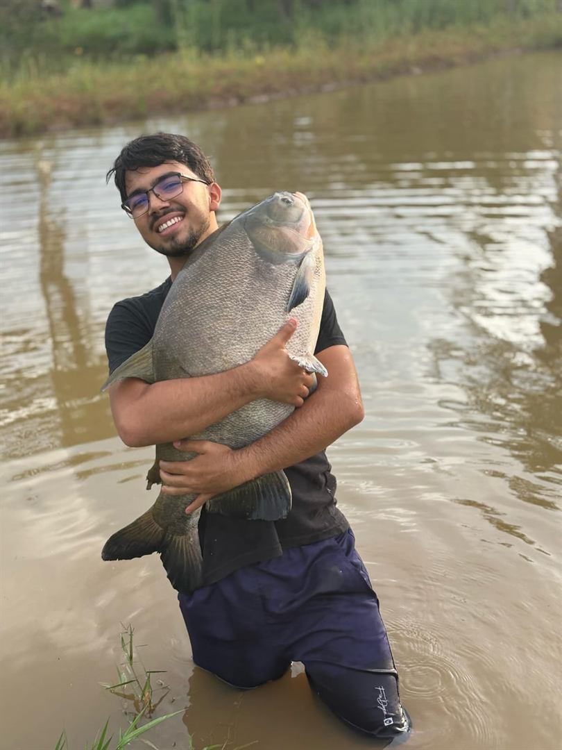Pescador celebrando grande peixe na água