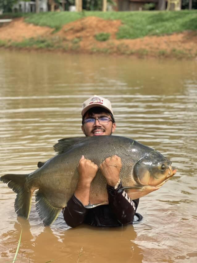 Pescador abraçado ao Tambacu dentro d'água